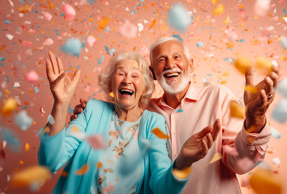 Couple de retraités heureux, fêtant un anniversaire. Des confettis tombent, joyeux.