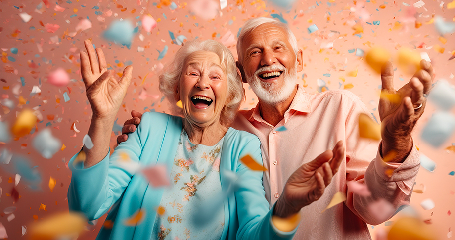 Couple de personnes âgées joyeux, fêtant un anniversaire. Des confettis tombent.